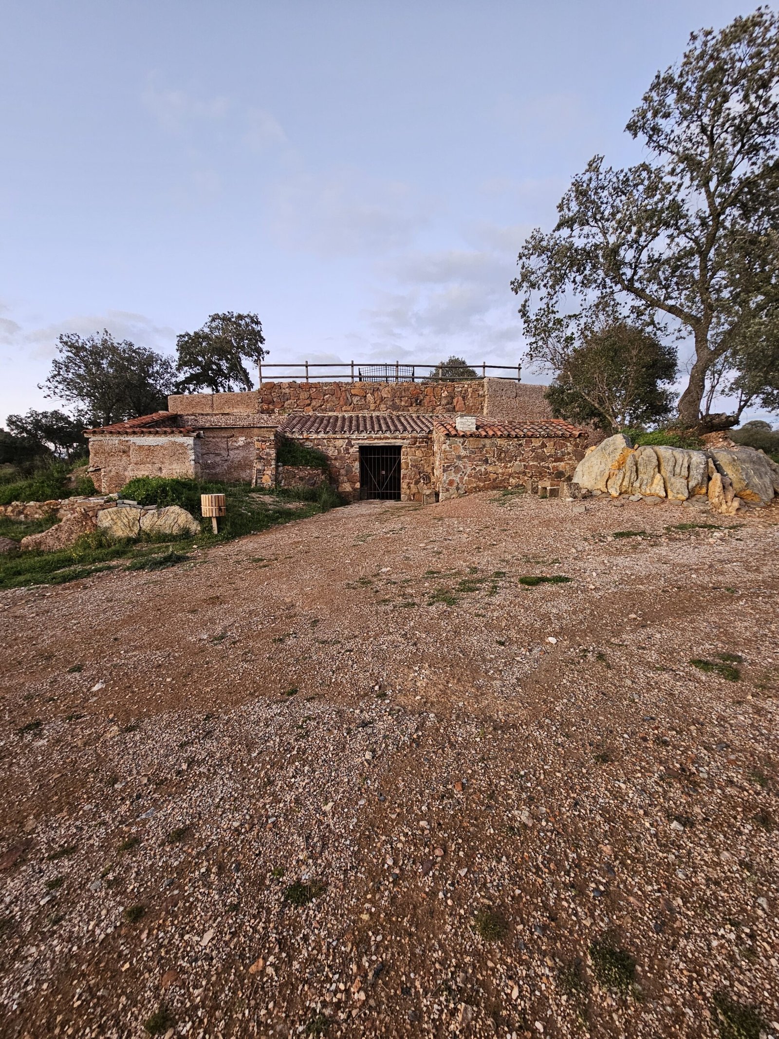 Ruta del Calerín en Villanueva del Duque, con ondulantes colinas verdes y campos de cultivo. En el horizonte se divisa la silueta de la Sierra Morena. Un camino de tierra serpentea por el campo, invitando a la exploración. (Ruta del Calerín, Villanueva del Duque, Córdoba, España)