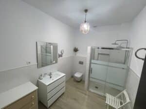 Plato de ducha con mampara de cristal y grifo termostático.